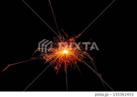 Sparkler glowing in dark during a night celebration event Sparkler glowing in dark during a night celebration event 135361453