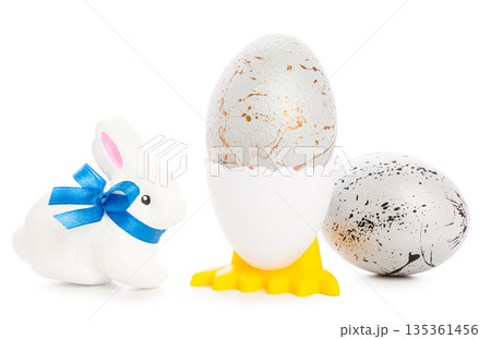 Decorative eggs and a bunny sit on a white background during the spring season Decorative eggs and a bunny sit on a white background during the spring season 135361456