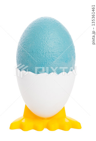 Blue egg in a white holder on yellow stand for decoration or celebration activities 135361461