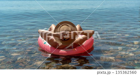 Woman floating water, enjoying summer vacation on inflatable ring in clear sea with copy space. Woman floating water, enjoying summer vacation on inflatable ring in clear sea with copy space. 135362560