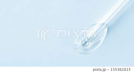 Drop of cosmetics and a pipette on a blue background. A product for skin, face or hair care. 135362815
