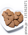 Heart-shaped gingerbread cookies on a white heart-shaped plate isolated on white background 135362871
