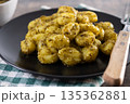 Gnocchi with pesto sauce served on black plate 135362881