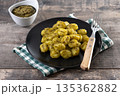 Gnocchi with pesto sauce served on black plate 135362882