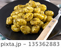 Gnocchi with pesto sauce served on black plate 135362883