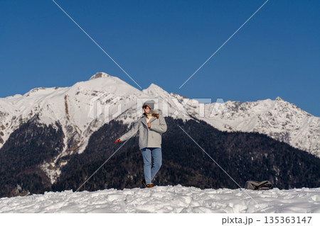 Mountains Woman Winter: Snowcapped Alps, solo female hiker enjoying scenic view, sunny day. Mountains Woman Winter: Snowcapped Alps, solo female hiker enjoying scenic view, sunny day. 135363147
