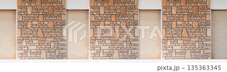Stone facade with roller shutters and textured wall Stone facade with roller shutters and textured wall 135363345