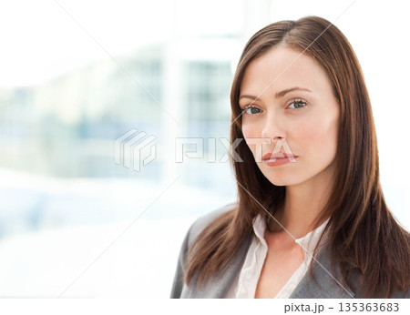 Businesswoman standing confidently in bright office space wearing grey blazer, copy space Businesswoman standing confidently in bright office space wearing grey blazer, copy space 135363683