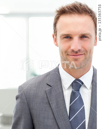 Mid adult man standing in office wearing grey suit, white shirt, blue striped tie, copy space 135363758
