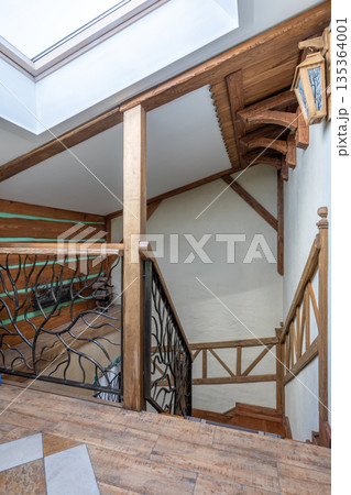 Rustic Wooden Staircase Interior with Skylight and Iron Railing 135364001