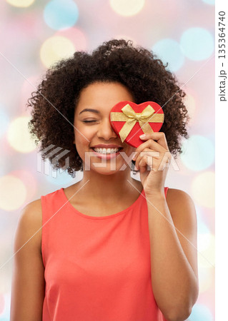 Smiling woman with heart gift box 135364740