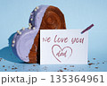 Father's Day WE LOVE YOU DAD wishes saying caption on greeting card Delightful heartshaped pastry croissant treat, beautifully topped with colorful frosting galore. Copy space. Food experimentation 135364961