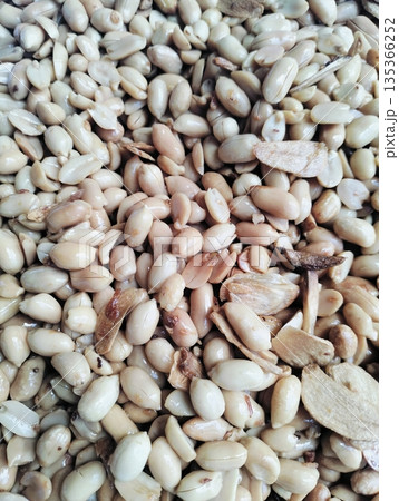 Roasted peanuts mixed with garlic as a traditional savory snack with crunchy texture and natural food background Roasted peanuts mixed with garlic as a traditional savory snack with crunchy texture and natural food background 135366252