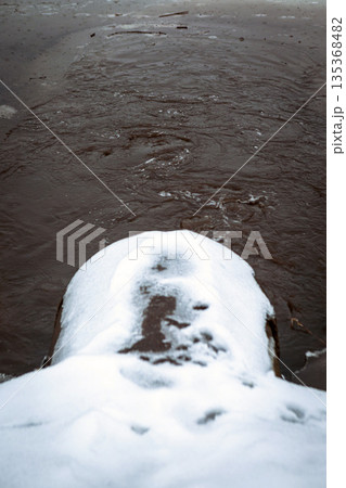 A pipe releases polluted water into the river. 135368482