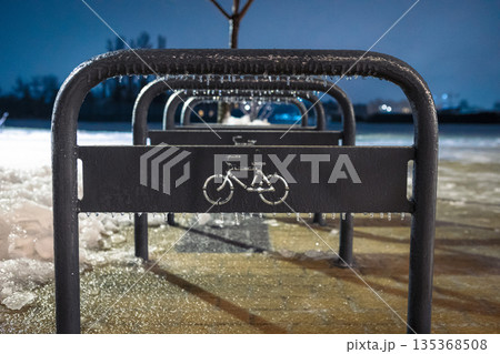 Sheffield type bicycle parking area in winter. Frozen metal structures on a snowy evening. 135368508