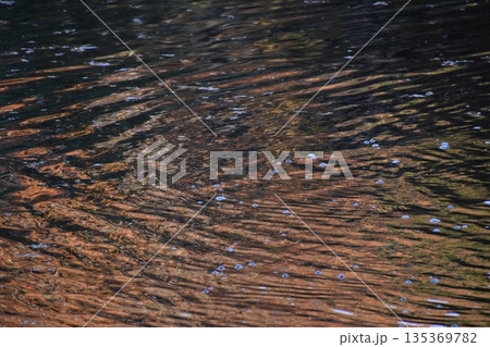 水面の波紋がえんじ色系をした背景素材 135369782