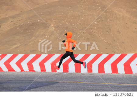 Fitness woman trail runner running on trail leading to Mount Everest in tibet, China Fitness woman trail runner running on trail leading to Mount Everest in tibet, China 135370623