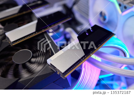 Elegant gaming hardware, High-performance RAM with cooling system, Premium illuminated memory module for gaming PCs, Sleek neon lit RAM with cooling and metallic heat sink design Elegant gaming hardware, High-performance RAM with cooling system, Premium illuminated memory module for gaming PCs, Sleek neon lit RAM with cooling and metallic heat sink design 135372187