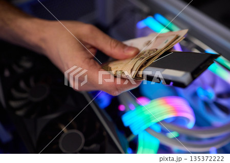 Hidden cash stored in computer memory modules, Covert operation involving cash hideaway inside memory hardware amid colorful RGB illumination and mining equipment Hidden cash stored in computer memory modules, Covert operation involving cash hideaway inside memory hardware amid colorful RGB illumination and mining equipment 135372222