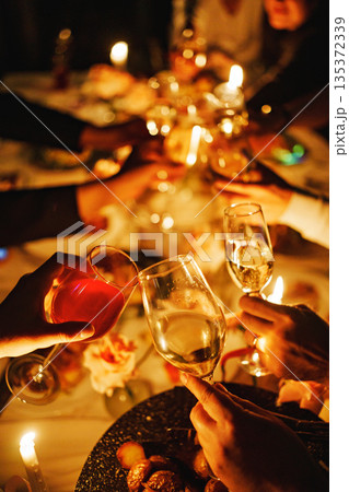 Celebration at a festive table with glasses raised 135372339