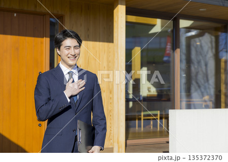 住宅展示場を案内する営業マン 住宅展示場を案内する営業マン 135372370