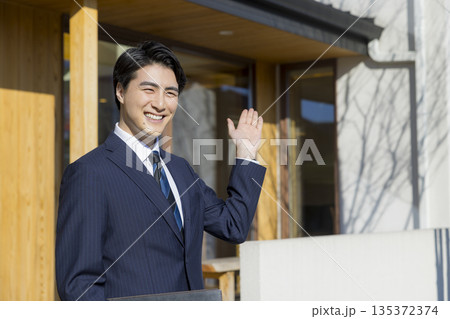 住宅展示場を案内する営業マン 住宅展示場を案内する営業マン 135372374
