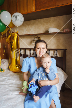 Happy mother celebrates child's first birthday at home Happy mother celebrates child's first birthday at home 135372409