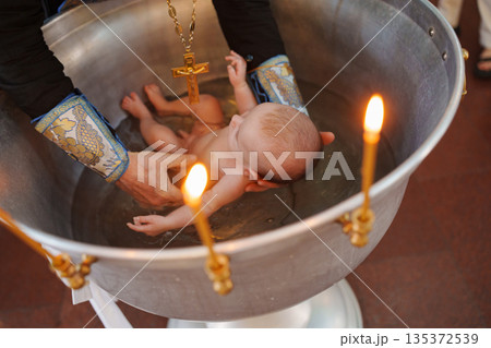 Baptism ceremony taking place in a church setting 135372539