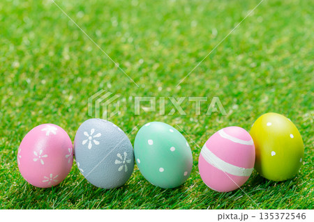 Colorful eggs arranged on green grass for an outdoor celebration in springtime 135372546
