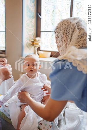 Family prepares baby for special celebration in home 135372559