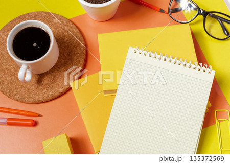 Working on tasks with coffee and notes on a colorful desk in the morning light Working on tasks with coffee and notes on a colorful desk in the morning light 135372569