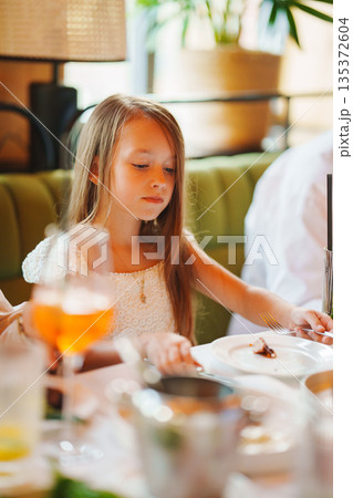 Young girl enjoying a meal at a colorful restaurant Young girl enjoying a meal at a colorful restaurant 135372604