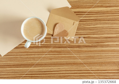 Coffee sits on a wooden table next to a small beige box at a cafe in the afternoon 135372668
