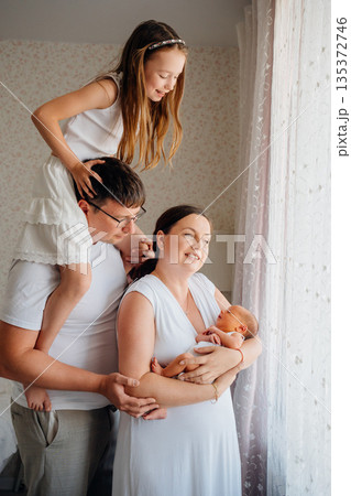 Family enjoys time together with newborn in home setting Family enjoys time together with newborn in home setting 135372746