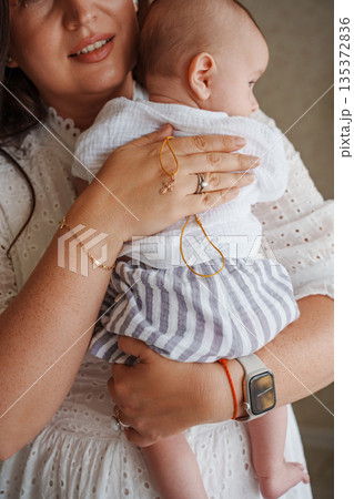 Baby held lovingly by parent against smooth background Baby held lovingly by parent against smooth background 135372836