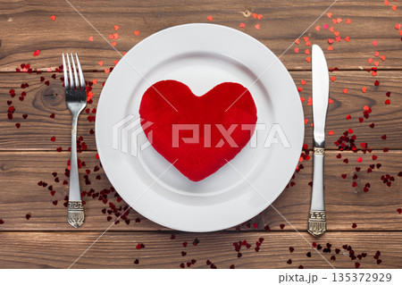 Heart shape decoration on a plate with utensils for a special meal event 135372929
