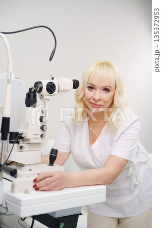 Ophthalmologist examines equipment in medical office Ophthalmologist examines equipment in medical office 135372953