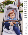 Child in stroller enjoying a sunny day outdoors 135372991