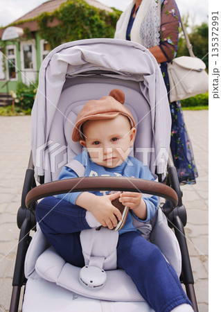 Child in stroller enjoying a sunny day outdoors 135372991