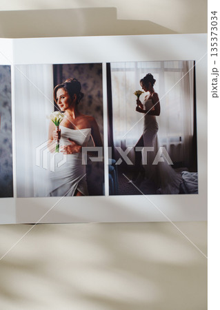 page of an open photo book with wedding photos on a white table 135373034