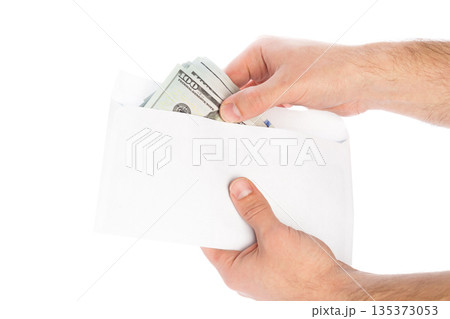 Person holds an envelope containing cash in hands ready to give money 135373053