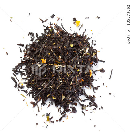 Dried black tea leaves mixed with orange peels on white background Dried black tea leaves mixed with orange peels on white background 135373062