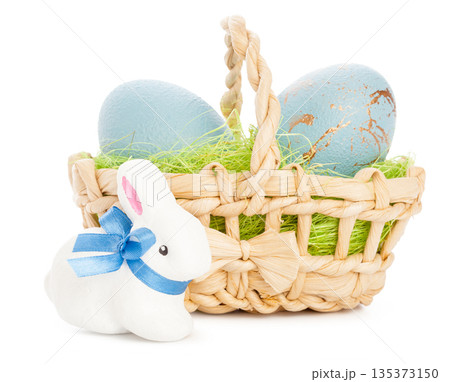 Easter basket with blue eggs and a white bunny on a simple background 135373150