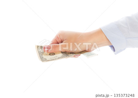 Hand holding a dollar bill in a transaction at a simple location Hand holding a dollar bill in a transaction at a simple location 135373248