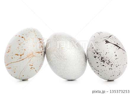 Decorative eggs arranged in a row on a white background during the spring season 135373253