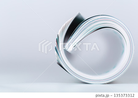 Curled stack of paper lies on surface in simple arrangement Curled stack of paper lies on surface in simple arrangement 135373312