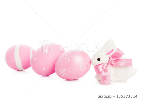 Pink Easter eggs and bunny with ribbon sitting on a white background 135373314