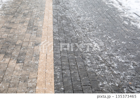 Icy Pedestrian Sidewalk Surface with Winter Frost on Paved Pathway Icy Pedestrian Sidewalk Surface with Winter Frost on Paved Pathway 135373465
