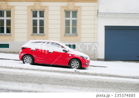 Red Car Covered in Snow on Urban Street 135374885