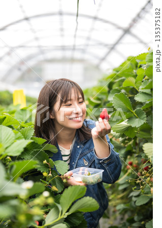 笑顔でいちごを持つ女性 笑顔でいちごを持つ女性 135375182